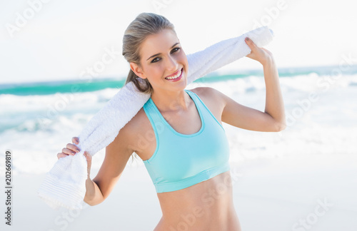 Cheerful sporty blonde in sportswear holding towel