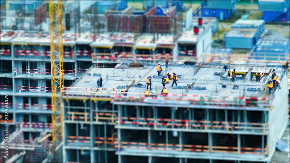 Time lapse tilt shift builders and cranes working on the construction site close up Time lapse tilt shift builders and cranes working on the construction site close up