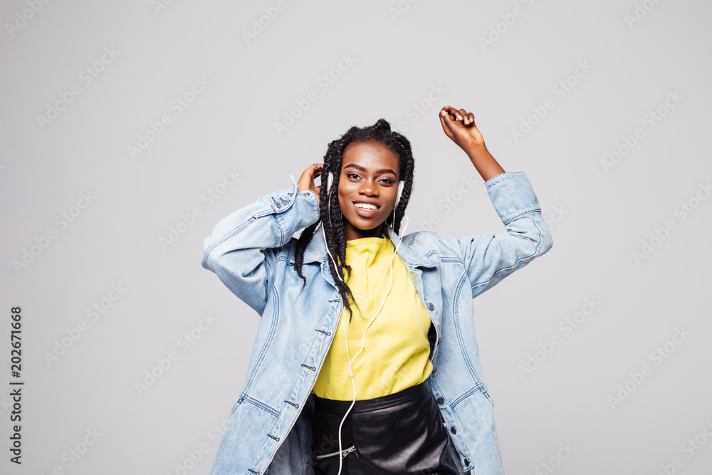 Φωτογραφία Close-up portrait afro american woman relaxing in headphones and funny dancing on gray background