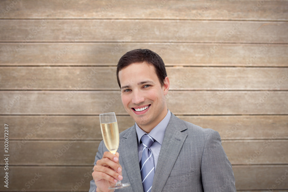 Fototapeta premium Businessman toasting with champagne against wooden surface with planks
