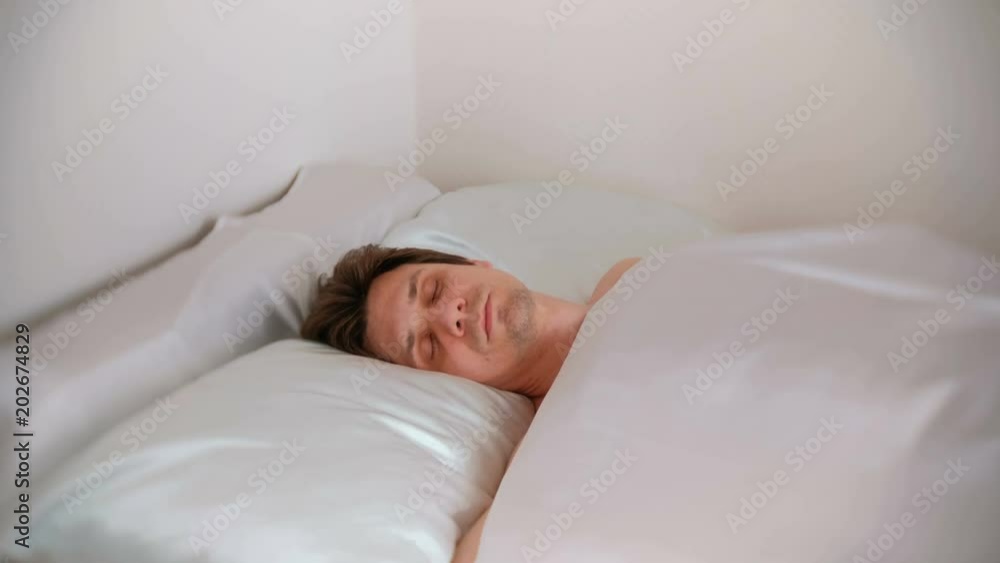 Young man sleeping uneasily in bed. Young man sleeping uneasily in bed.