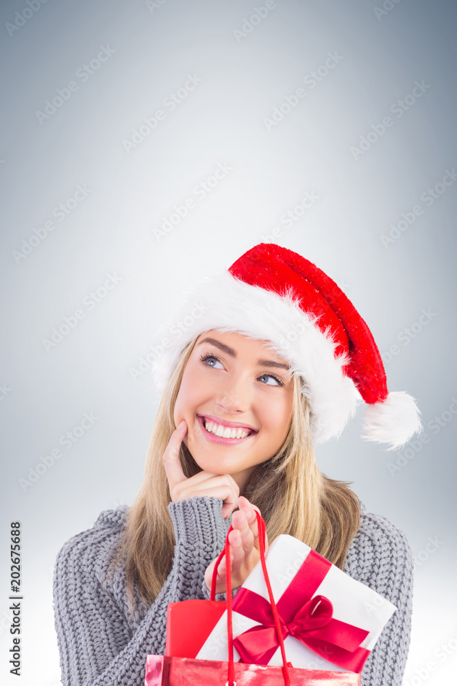 Festive blonde holding christmas gift and bag on vignette background Festive blonde holding christmas gift and bag on vignette background