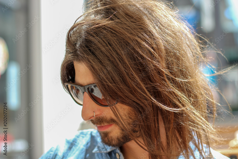 authentic handsome young man with long hair outdoors authentic handsome young man with long hair outdoors