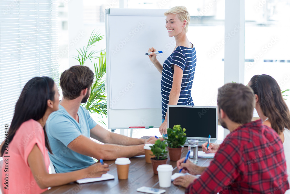 Obraz premium Casual businesswoman giving presentation to her colleagues