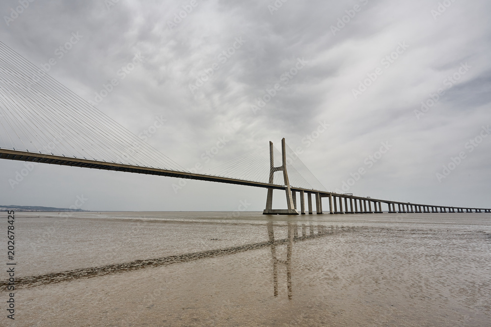 The Vasco da Gama Bridge in Lisbon, Portugal in a summer day. beautiful colors The Vasco da Gama Bridge in Lisbon, Portugal in a summer day. beautiful colors