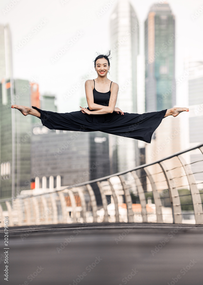 Ταπετσαρία Cute Young woman athlete with beautiful smile performs a perfect straddle leap h