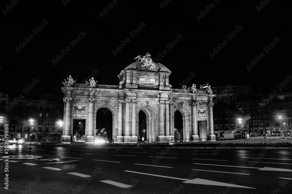 Night view of The Puerta de Alcala at night - a monument in the Independence Square in Madrid, Spain. Black and white