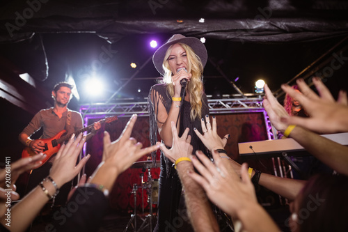Cheerful female singer performing on stage at nightclub