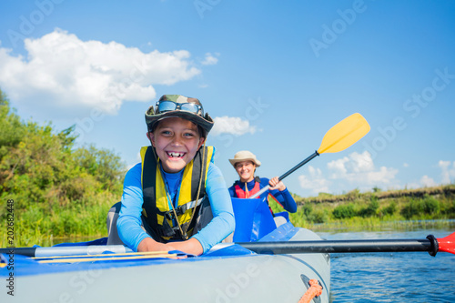 Happy boy kayaking on the river on a sunny day during summer vacation © Max Topchii