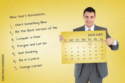 Businessman pointing at calendar he is holding against yellow card