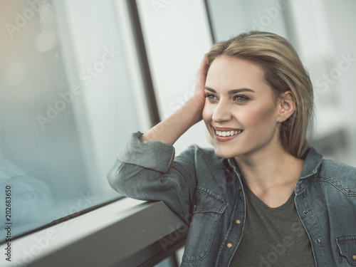 Portrait of pensive young girl dreaming while looking at window. Reverie concept