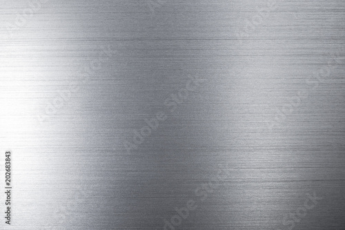Close up industrial background of fractally scratched direct horizontal lines to silver metal/stainless steel surface. Creative detail macro photography.