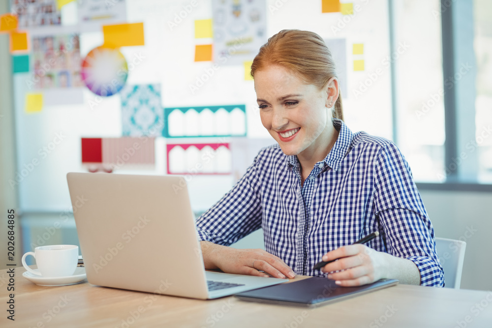 Female graphic designer using graphics tablet Female graphic designer using graphics tablet