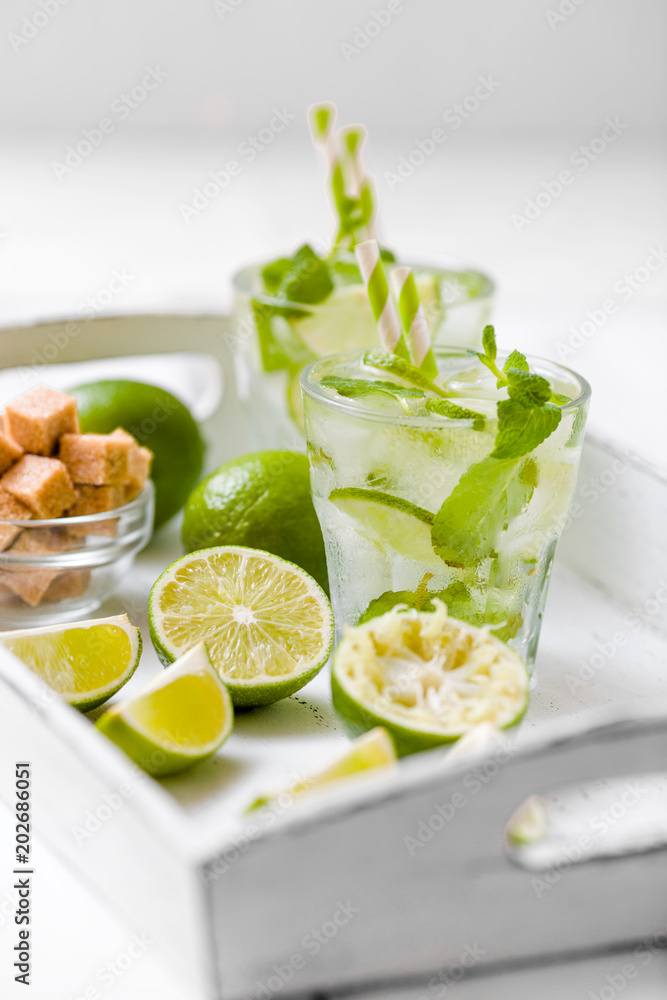 Summer refreshing cocktail mojito with lime and mint on white wooden vintage background. Summer refreshing cocktail mojito with lime and mint on white wooden vintage background.