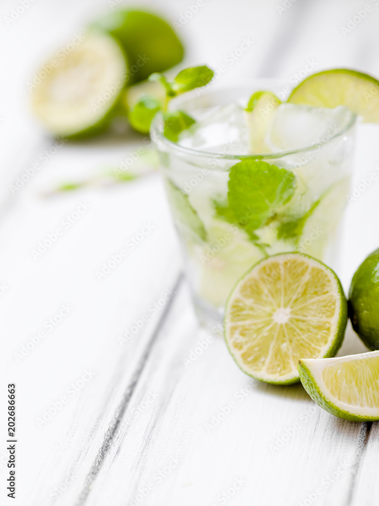 Summer refreshing cocktail mojito with lime and mint on white wooden vintage background. Summer refreshing cocktail mojito with lime and mint on white wooden vintage background.