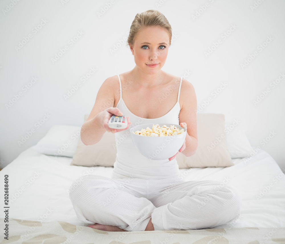 Natural content blonde holding remote and popcorn Natural content blonde holding remote and popcorn