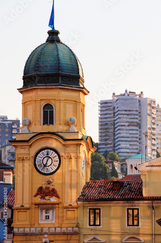 Beautiful landmark Baroque clock tower on main street Korzo in morning sunlight with ugly Socialist era high-rise buildings in background  Rijeka city Croatia former Yugoslavia Balkans Europe