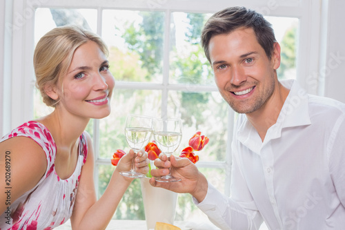 Happy young couple toasting wine glasses