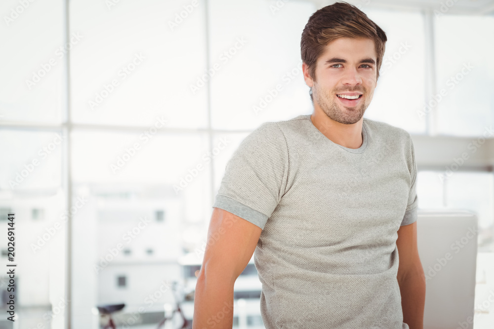 Businessman smiling while standing against window Businessman smiling while standing against window