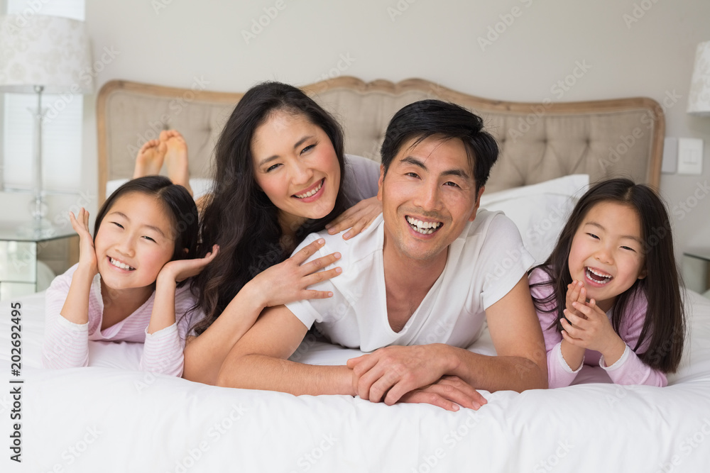 Cheerful family of four lying in bed Cheerful family of four lying in bed