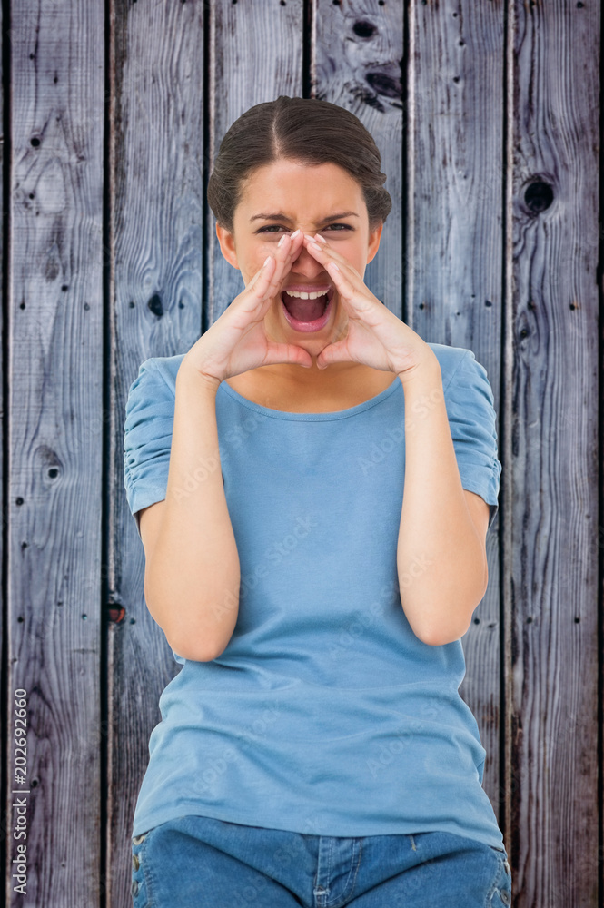 Fototapeta premium Pretty brunette shouting against grey wooden planks