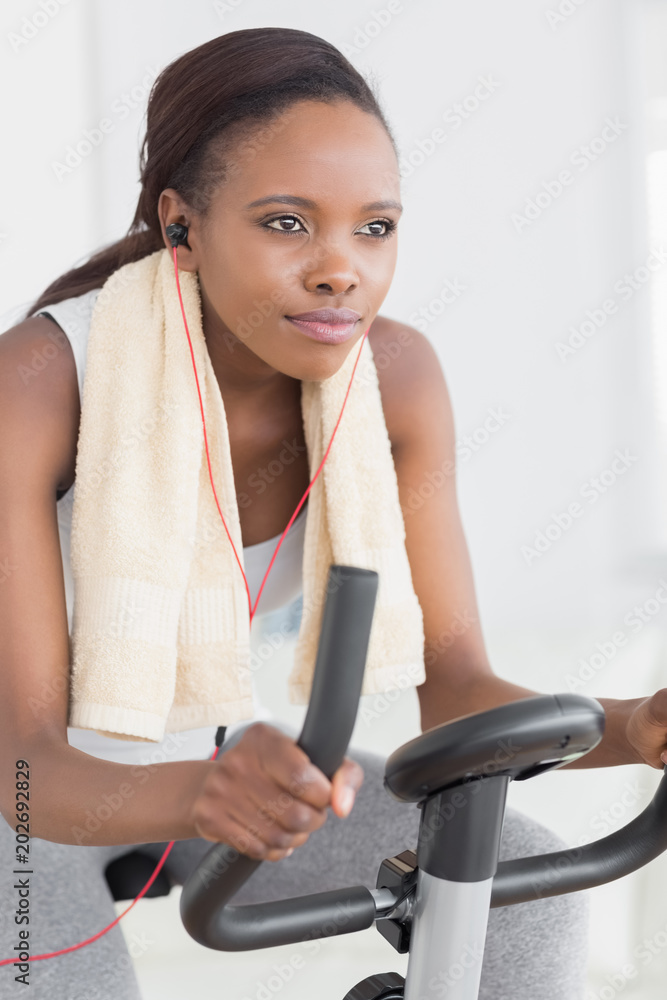 Concentrated black woman doing exercise bike
