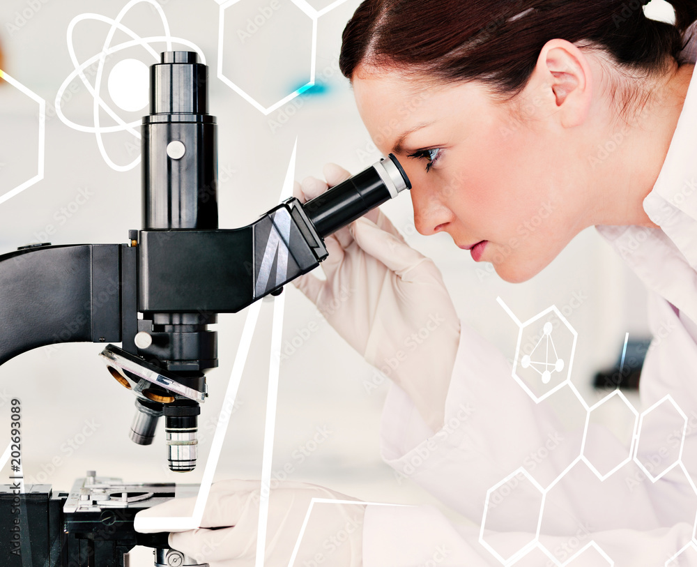 Attractive redhaired scientist looking through a microscope against science and medical graphic Attractive redhaired scientist looking through a microscope against science and medical graphic
