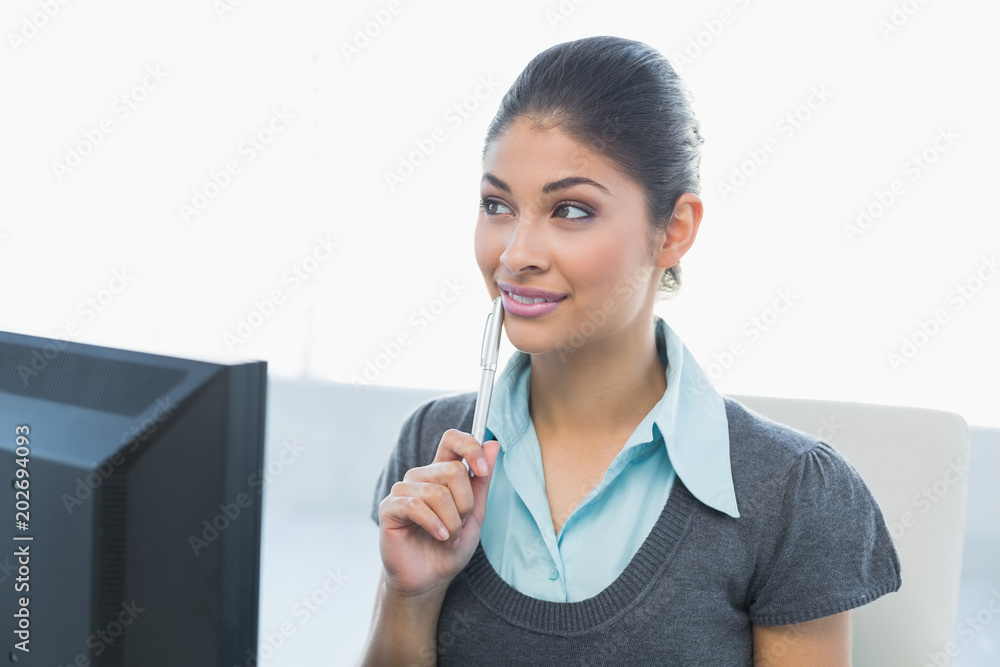 Thoughtful businesswoman looking away in front of computer Thoughtful businesswoman looking away in front of computer