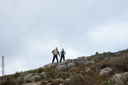 Couple standing on rocky landscape against clear sky