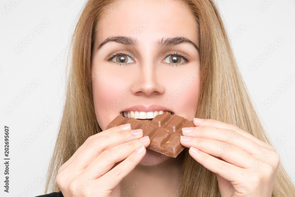 Gorgeous blond woman bites in chocolate Gorgeous blond woman bites in chocolate