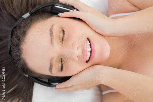 Woman enjoying music in bed