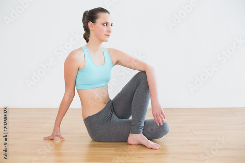 Fit woman in cowface posture in fitness studio photo