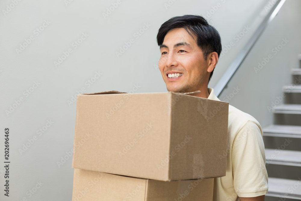 Smiling young man carrying boxes Smiling young man carrying boxes