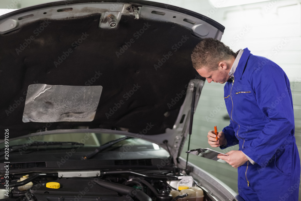 Mechanic holding a clipboard Mechanic holding a clipboard