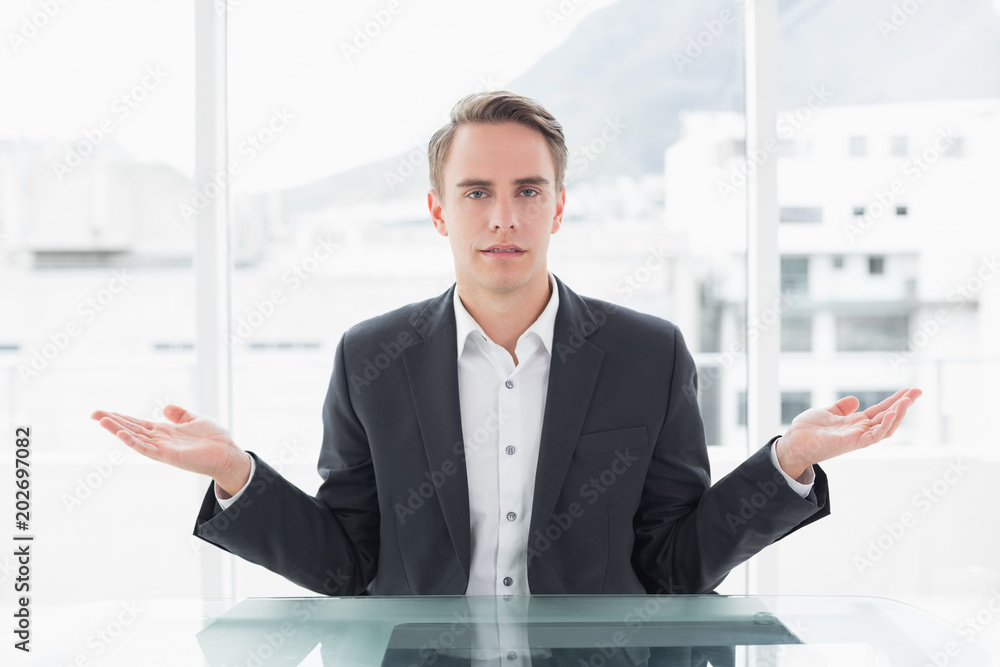 Fototapeta premium Serious businessman with hand gesture at office desk