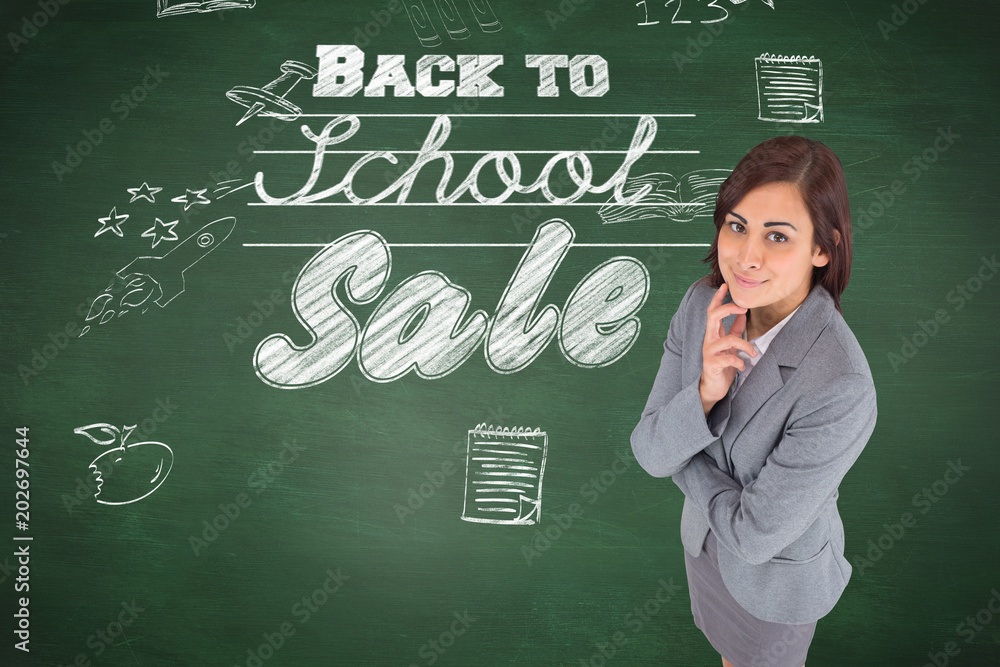 Composite image of smiling thoughtful businesswoman against green chalkboard