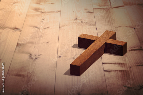 Wooden cross against bleached wooden planks background