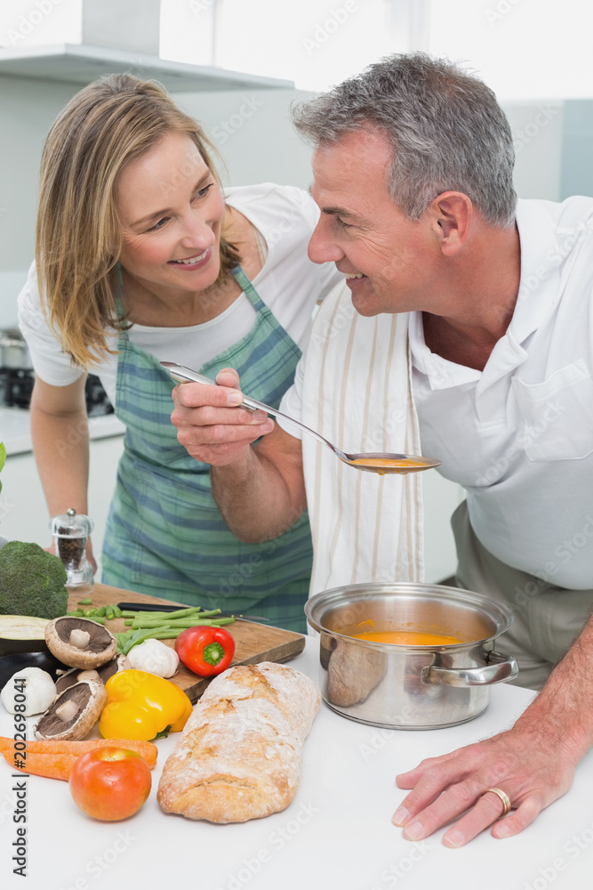 Couple preparing food together in kitchen Couple preparing food together in kitchen
