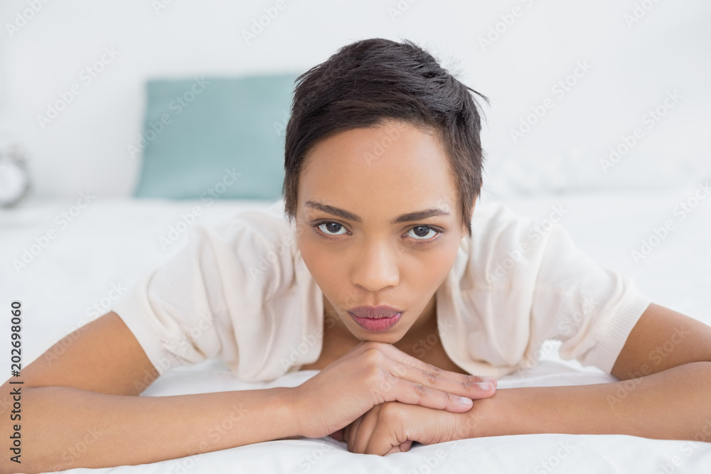 Serious pretty young woman relaxing in bed Serious pretty young woman relaxing in bed