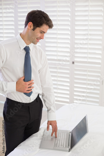 Businessman using laptop at hotel room