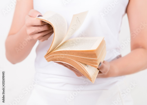 Close up of the young Asian woman with a book. Isolated on white background. Studio lighting. Concept for education