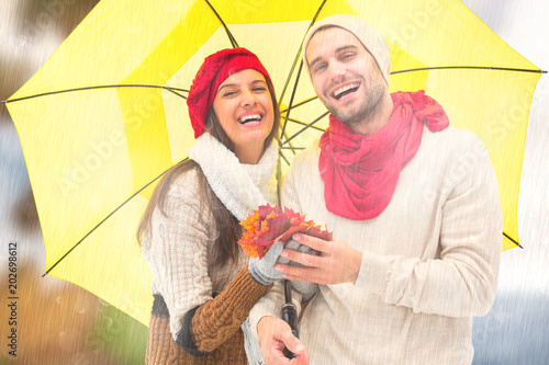 Fotografie Autumn couple holding umbrella against autumn turning to winter