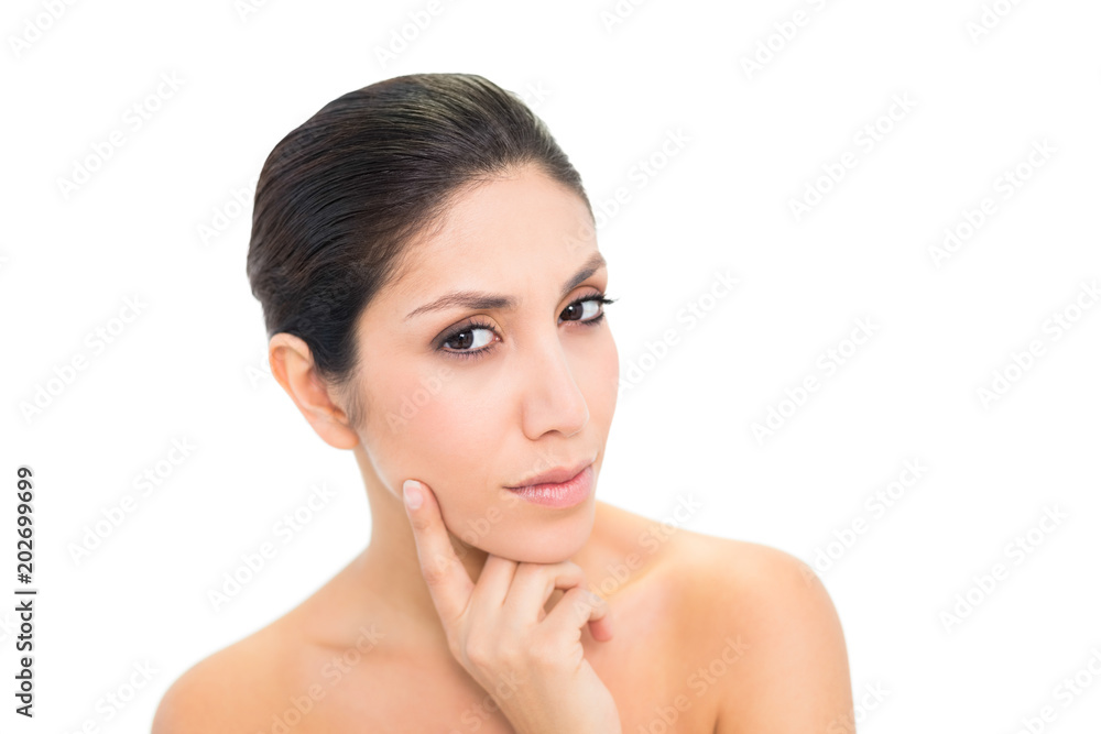 Thoughtful brunette with finger on her face looking at camera Thoughtful brunette with finger on her face looking at camera