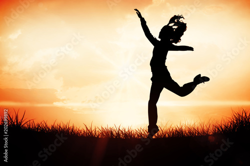 Full length side view of a sporty young blond jumping against orange sunrise