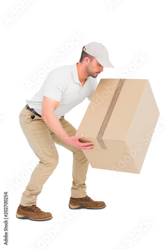 Delivery man crouching while picking cardboard box 
