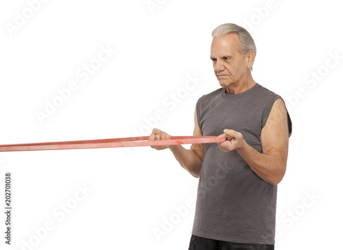Senior man pulling rubber exercise band