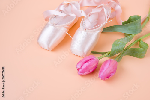 Ballet shoes with tulips on yellow background