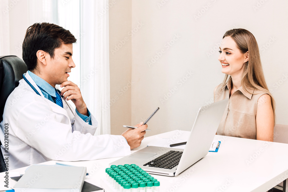 Doctor discussing and consulting with female patien on doctors table in hospital.healthcare and medicine Doctor discussing and consulting with female patien on doctors table in hospital.healthcare and medicine