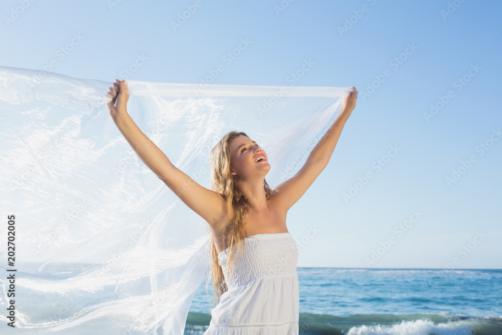 Beautiful calm blonde in white sundress on the beach with scarf Beautiful calm blonde in white sundress on the beach with scarf