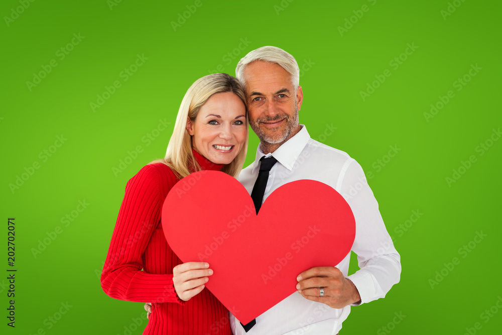 Handsome man getting a heart card form wife against green vignette